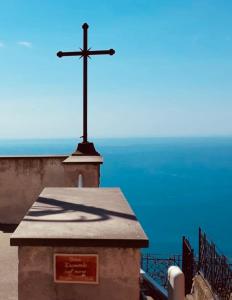 a cross on top of a building with the ocean in the background at Tramonto sul Mare in Framura