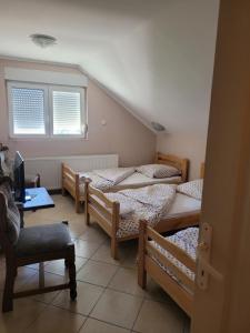 Zimmer mit 4 Betten, einem Schreibtisch und einem Fenster in der Unterkunft Koba in Bački Monoštor