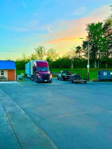 a red van parked in a parking lot with a trailer at Days Inn by Wyndham Athens in Athens