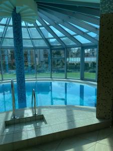 - une piscine dans un bâtiment doté d'un plafond en verre dans l'établissement Avangard Resort, à Świnoujście