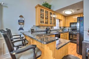 a kitchen with wooden cabinets and a large island with stools at Pet-Friendly Wedowee Home with Hot Tub and Dock! in Wedowee