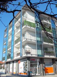 wysoki biały budynek z balkonami przy ulicy w obiekcie Residence Ambria w Grado
