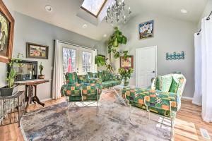 a living room with green furniture and a chandelier at Pittsford Trolley Home - Near Erie Canal! in Pittsford