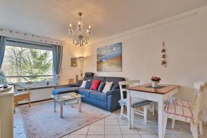 een woonkamer met een blauwe bank en een tafel bij Carpe Diem Carpe Diem Appartement 109 in Niendorf
