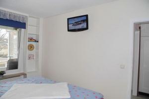 a bedroom with a tv on a white wall at Carpe Diem Carpe Diem Appartement 109 in Niendorf +32 photos