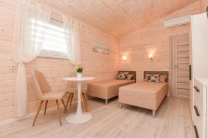 uma pequena sala de estar com uma mesa e um sofá em Ramybės oazė em Šventoji