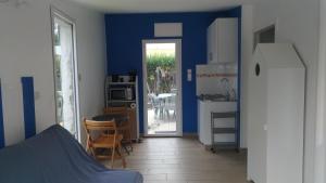a kitchen with blue walls and a kitchen with a table at Agréable studio indépendant proche mer in Saint-Hilaire-de-Riez +5 photos