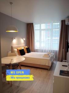a bedroom with a large bed and a table at Studio Galaxy 2 floor in Kyiv