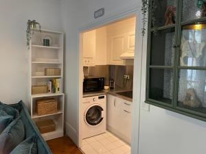 una cucina con lavatrice e asciugatrice in camera di The Avenue Ternes Paris a Parigi