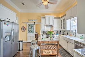 a kitchen with white cabinets and a stainless steel refrigerator at Renovated Carnegie Cottage - Walk to Dtwn! in Winnsboro