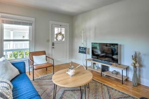 a living room with a blue couch and a tv at Unique Historic Cottage - Walk to Main St! in Sutter Creek