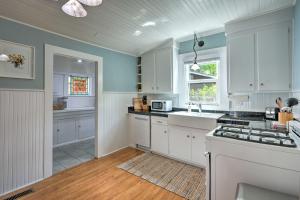 a kitchen with white cabinets and a stove top oven at Unique Historic Cottage - Walk to Main St! in Sutter Creek