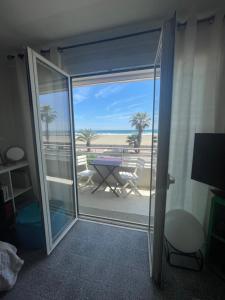 eine Glasschiebetür mit Strandblick in der Unterkunft DOMUS in Canet-en-Roussillon