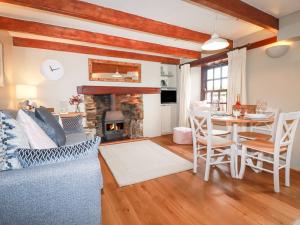 a living room with a table and a fireplace at 4 Trenhaile Terrace in Truro