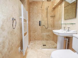 a bathroom with a sink and a toilet and a shower at 4 Trenhaile Terrace in Truro