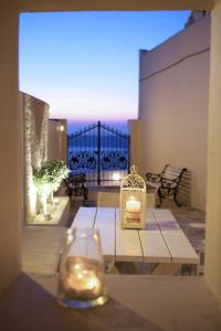 Sunset View Villa Santorini - with Outdoor Jacuzzi في فِروستيفاني: وجود شمعة على طاولة في الفناء