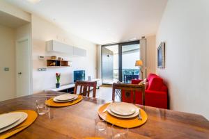 a dining room with a table and a red chair at Primera línea de mar con piscina, gimnasio y parking 2 hab y 2 baños in Villajoyosa