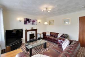 un soggiorno con divano in pelle e TV di Cedar Drive, Holbeach - 1 to 4 - Self Catering a Holbeach