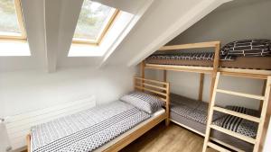 two bunk beds in a attic room with windows at Holiday Apartments Falke in Brienz