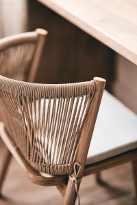 una silla de madera sentada frente a una mesa en AK Mykonos en Mykonos ciudad