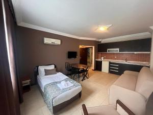 a hotel room with a bed and a living room at City Inn Family Apart in Antalya