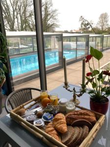 a tray of breakfast food on a table near a pool at Desirad in La Clisse