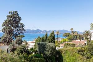 a view of the ocean from a garden at Suite Riviera - Sea View - Clim - 50M Plage - Residence de standing - Spacieux 180 M2 - Parking in Cannes