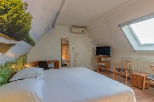 a bedroom with a large white bed and a window at Apollonia in Aalter