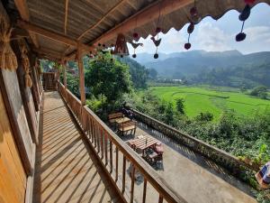 an outdoor balcony with a view of a green field at La Beauté Bắc Hà in Bắc Hà