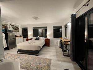 1 dormitorio con cama, escritorio y cocina en Private Room On Waterfront Property With Hot Tub Firepit - Sea Esta en Ucluelet