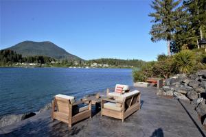 a table and two chairs sitting next to a lake at Private Room On Waterfront Property With Hot Tub & Firepit - Sea Esta in Ucluelet