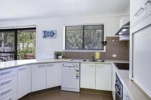 a kitchen with white cabinets and white appliances at Quaint Private Room in Pleasant Ashmore in Gold Coast