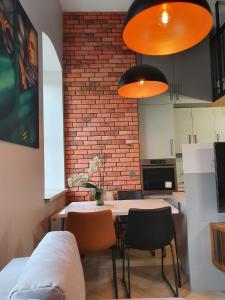 uma cozinha com uma mesa e cadeiras e uma parede de tijolos em Apartament Hania em Tykocin