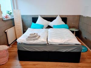 a bed with white sheets and blue pillows at Ferienwohnung Familie Schwarz in Germersheim