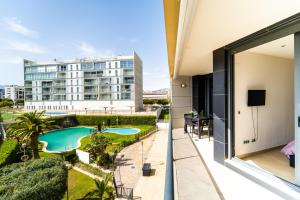 a view from the balcony of a building with a swimming pool at Primera línea de mar con piscina, gimnasio y parking 2 hab y 2 baños in Villajoyosa