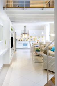 Il comprend un salon et une cuisine avec des murs et des sols blancs. dans l'établissement Mammare Sorrento Loft, à Sorrente