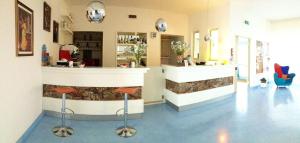 a salon with a counter and stools in a room at Kalos Hotel in Maruggio