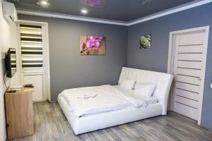 um quarto com uma cama branca num quarto em Видовая квартира в новострое в центре Киева em Kiev