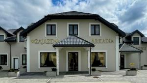 a large white building with a sign on it at Zajazd Arkadia in Siemiatycze