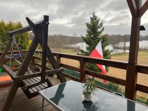 una mesa y una silla en una terraza con bandera en A&R Kaszuby Natura Dom Wypoczynek, en Gowidlino