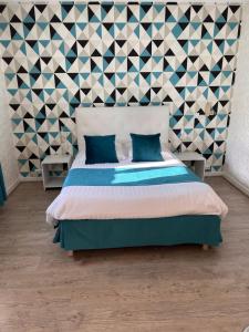 a bedroom with a bed and a geometric wall at Hotel Alpes Cevennes in Guilherand