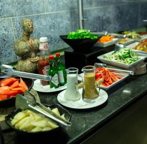 a buffet with plates of food and drinks on a counter at Accra City Hotel in Accra