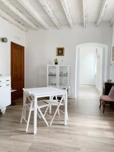 una mesa y sillas blancas en una habitación blanca en "La Cascina" Bed & Breakfast, en Desenzano del Garda