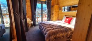 een slaapkamer met een bed en een groot raam bij Hôtel Spa L'Oxygène in Valmorel