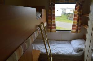een kleine slaapkamer met een stapelbed en een raam bij zee van Buren in Buren