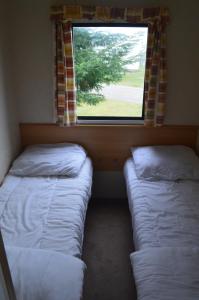twee bedden in een kamer met een raam bij zee van Buren in Buren