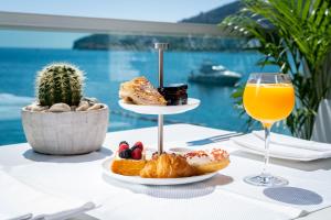 a table with a plate of food and a glass of orange juice at Dukley Hotel & Resort in Budva