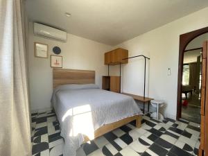 a bedroom with a bed and a checkered floor at Casa Ixaya by Barrio México in Guadalajara