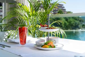 a table with a plate of food and a drink at Dukley Hotel & Resort in Budva