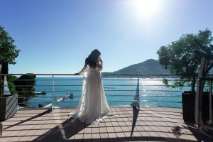 a woman in a white dress standing on a boardwalk at Dukley Hotel & Resort in Budva